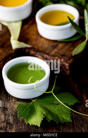 Öle, Gewürze und Kräuter. Trauben, Oliven und Mais Öle frische Kräuter Zitronen, Paprika. Stockfoto