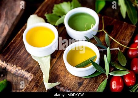 Öle, Gewürze und Kräuter. Trauben, Oliven und Mais Öle frische Kräuter Zitronen, Paprika. Stockfoto