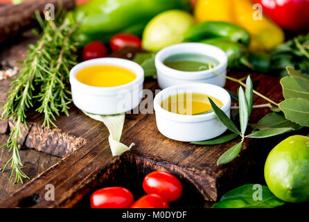 Öle, Gewürze und Kräuter. Trauben, Oliven und Mais Öle frische Kräuter Zitronen, Paprika. Stockfoto