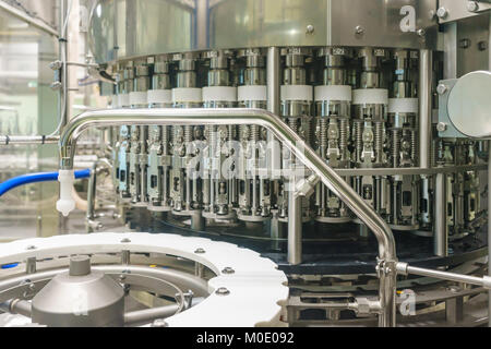 Flasche füllen, Getränkeflaschen mit Trinken durch eine industrielle Maschine in einer Getränkefabrik gefüllt Stockfoto