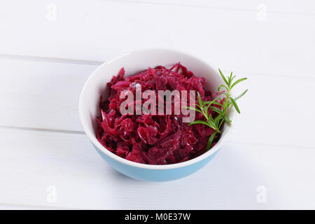 Schüssel von eingelegtem Rotkohl auf weißem Holz- Hintergrund Stockfoto