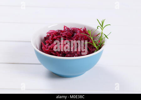 Schüssel von eingelegtem Rotkohl auf weißem Holz- Hintergrund Stockfoto