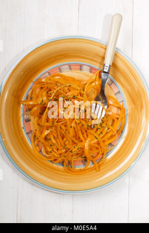 Spiralized butternut squash mit hausgemachten Salatsoße auf einer Platte Stockfoto