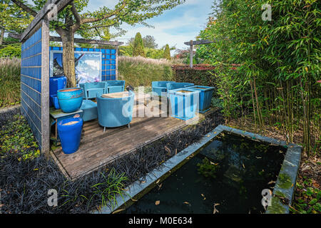 Apeltern, Niederlande, 29. September 2017: eingerichteten Ecke im Garten schön mit einer blauen Wand im Hintergrund. Stockfoto