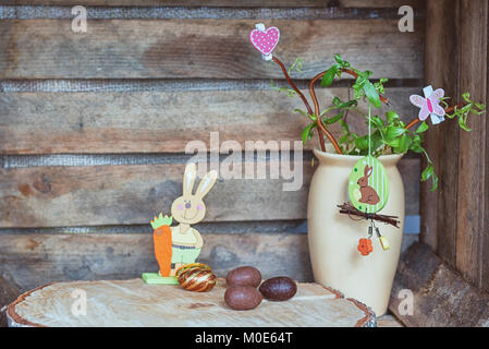 Ostern Zusammensetzung der Ostereier, ein sich winden, Hazel mit Kaninchen, Schmetterling und Herz und eine künstliche rabbot mit Karotte Stockfoto