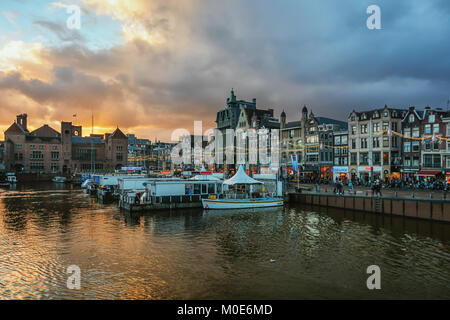 Amsterdam, Niederlande, 16. Dezember 2017: Anlegestelle für die Ausflugsschiffe auf dem Kanal Damrak in der Altstadt von Amsterdam. Stockfoto