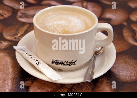 Eine Tasse Kaffee auf dem Tisch - Kaffeetasse auf Tisch mit Kaffeebohnenmuster Stockfoto