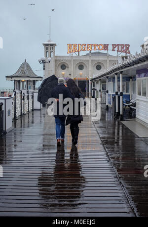 Brighton UK 21. Januar 2018 - Ein paar tapfere der schwere Regen, da Sie für einen Spaziergang gehen heute entlang von Brighton Palace Pier mit einigen Teilen Großbritanniens Prognose mehr Schnee Foto von Simon Dack Credit: Simon Dack/Alamy Leben Nachrichten zu haben Stockfoto