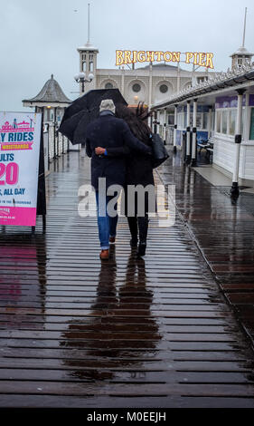 Brighton UK 21. Januar 2018 - Ein paar tapfere der schwere Regen, da Sie für einen Spaziergang gehen heute entlang von Brighton Palace Pier mit einigen Teilen Großbritanniens Prognose mehr Schnee Foto von Simon Dack Credit: Simon Dack/Alamy Leben Nachrichten zu haben Stockfoto