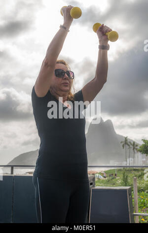 Model Released: reife Frau (70-79) Training mit Kurzhanteln an öffentlichen Turnhalle in Ipanema, Rio de Janeiro, Brasilien Stockfoto