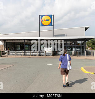 Frau zu Fuß in Richtung einen LIDL Supermarkt, Newtown, Powys, Wales, Großbritannien Stockfoto