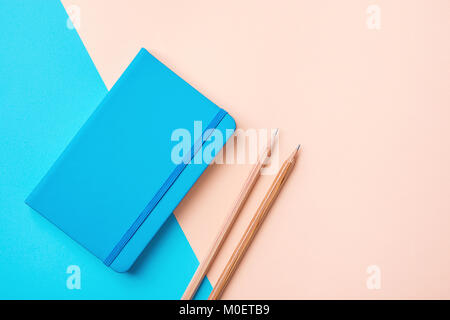 Schreiben Notepad Holz Bleistifte auf Kontrast Blau Peach Pink Pastell Farbe Hintergrund Kombination. Geschäft Ausbildung Routine Organisation Planung Konzept Stockfoto