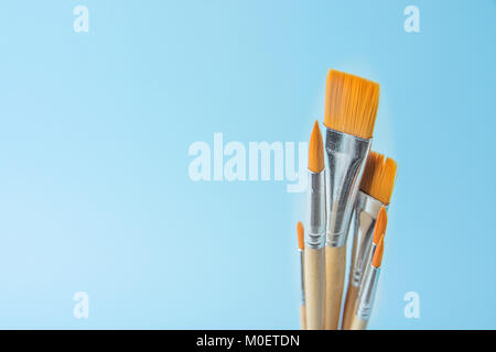 Bündel von verschiedenen Arten von Pinseln auf Farbverlauf hellblau hinterlegt. Kopieren Sie Raum für Kunstwerke Schrift Kalligraphie Text Inspirational Zitat. Crea Stockfoto