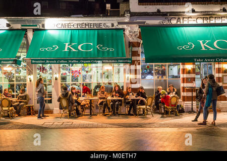 Menschen essen Outside cafe in Abend, Kensington, London, UK Stockfoto