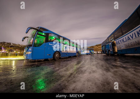 Reykjavik, Island. Dezember 2017. Sightseeing Tour Busse parken auf einem gefrorenen Straße in einer Winternacht in Island warten auf Aurora Borealis. Stockfoto