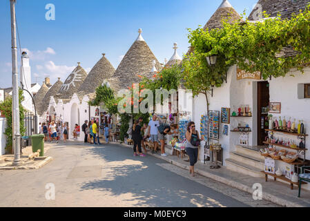 Alberobello, Italien - 3. September 2016: Touristen besuchen die Via Monte S. Michele Straße mit vielen Souvenirläden in der Stadt der Trulli. Stockfoto