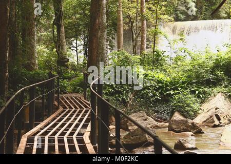 Stahl Brücke mit sridith Wasserfall im tropischen Regenwald auf khaoko bei Petchabun leben, Thailand Stockfoto