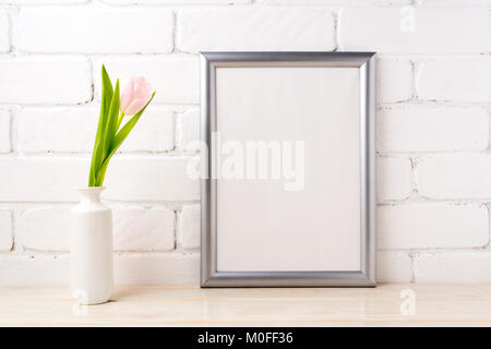 Silver frame Mockup mit soft pink tulip in weiße Vase in der Nähe der weiß gestrichenen Wand. Leeren Rahmen mock up für Präsentation Artwork. Framing Vorlage f Stockfoto