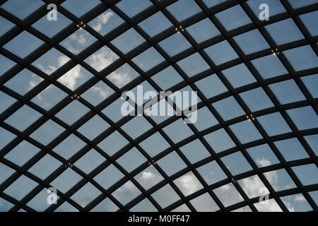 Suchen durch eine schwarze Steel grid am blauen Himmel mit Wolken Stockfoto