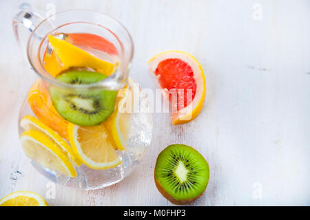 Erfrischend kaltem Wasser mit Zitrone, Kiwi, Grapefruit auf einer hölzernen Hintergrund. Konzept der Diät. Diät zur Gewichtsreduktion. Stockfoto