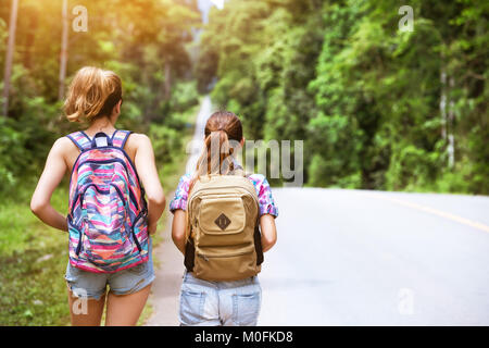Zwei Mädchen mit Rucksäcken werden durch geraden Straße Stockfoto