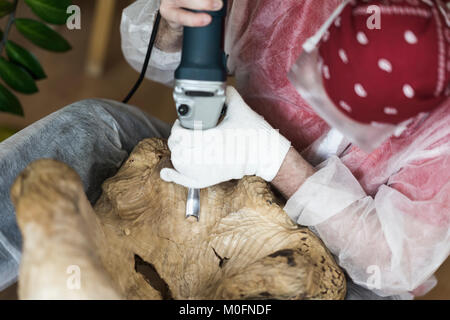 Holzschnitzer mit Brille Schnitzerei aus natürlichen Edelsteinen Holz, Kunst Objekt für die Dekoration von Haus. Holzschnitzer Hände mit Meißel. Konzept der handgefertigten, Professionalität, Hobby Stockfoto