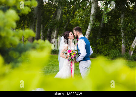 Süße ehe Paar in Liebe gehen in die grüne Natur Landschaft Hintergrund zu küssen. Stockfoto