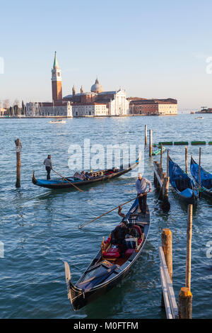 Gondeln in Rio de Palazzo o de Canonica bei Sonnenuntergang, San Marco, Venedig, Italien mit Blick über St. Marks Becken zu San Giorgio Maggiore Stockfoto