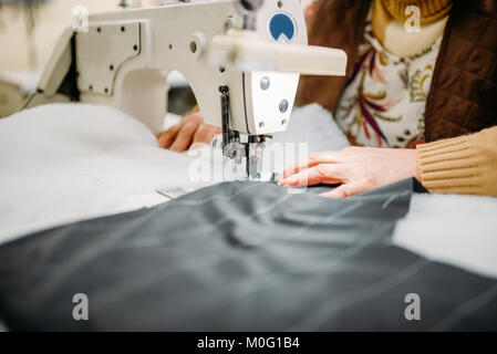 Näherin näht Stoffen auf einer Nähmaschine. Tailoring oder Schneidern auf Kleidung Fabrik, Handarbeit Stockfoto