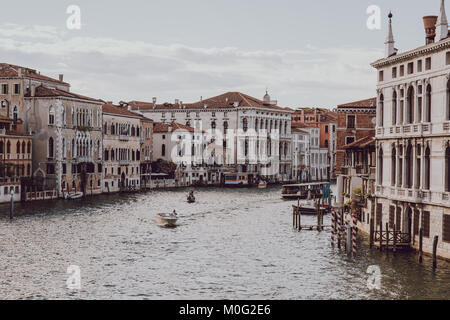 Eigenes Boot am Canal Grande in Venedig mit bunten Häuser auf beiden Seiten. Boote sind die wichtigsten Verkehrsmittel in der Stadt. Stockfoto