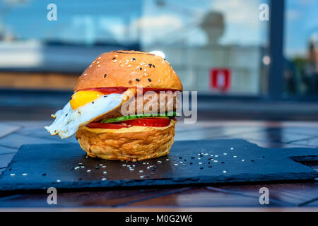In der Nähe von frisch zubereitet Restaurant Burger mit Ei auf dem Schwarzen Brett Stockfoto