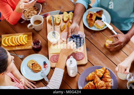 Personen mit Frühstück in der Tabelle mit Nahrungsmitteln Stockfoto