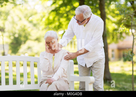 Ältere Frau leidet unter Kopfschmerzen im Freien Stockfoto