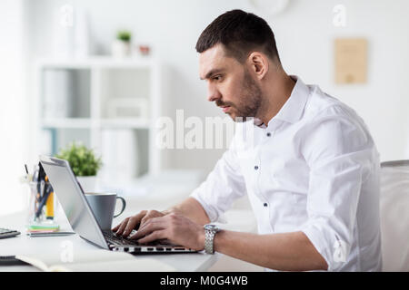 Geschäftsmann, die Eingabe auf Laptop im Büro Stockfoto