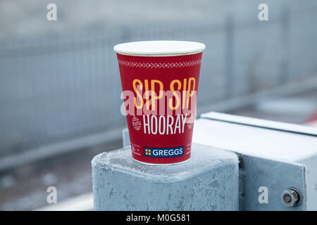 Ein greggs Weihnachten Tasse zum Mitnehmen auf eine Säule am Anniesland Bahnhof in Glasgow sitzen. Die Tasse Logo ist Sip Sip Hurra. Stockfoto