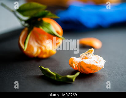 Eine Nahaufnahme eines frischen saftigen Clementinen mit grünen Blättern Stockfoto