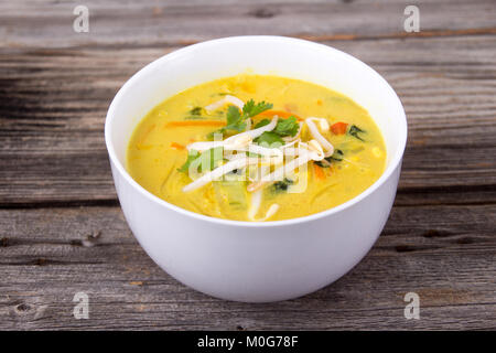 Leckere Thai curry Coconut chiken Soup Bowl über rustikale plank Hintergrund Stockfoto