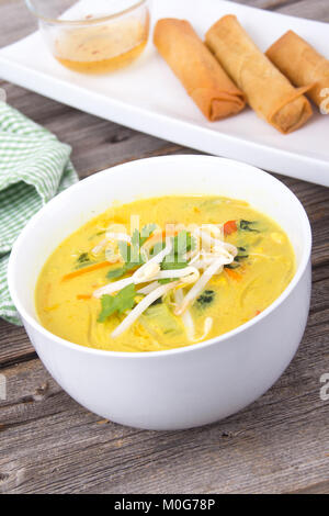 Leckere Thai curry Coconut chiken Soup Bowl über rustikale plank Hintergrund Stockfoto