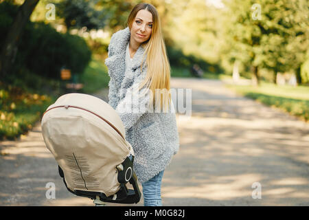 Junge Mutter mit dem Kinderwagen schieben Stockfoto