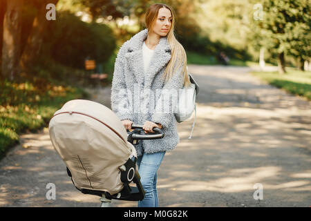 Junge Mutter mit dem Kinderwagen schieben Stockfoto