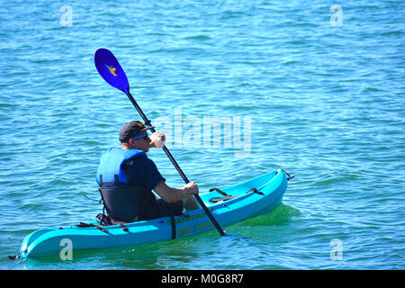 Junger Mann Sonnenbrille tragen beim Paddeln in Bellingham Bay im pacifc Norhwest Stadt von Bellingham, Washington, USA. Er trägt eine Schwimmweste. Stockfoto