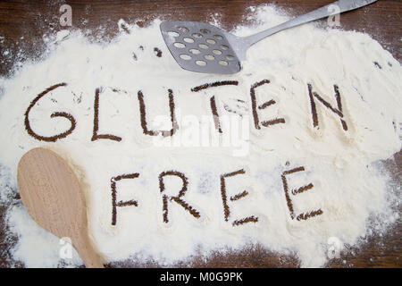 Mehl von Weizen und kochen Tools auf dem Küchentisch. Glutenfreie text auf Mehl geschrieben Stockfoto