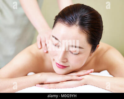 Nahaufnahme des Gesichts eines schönen jungen asiatischen liegende Frau auf der Vorderseite auf dem Bett, die Massage in der Spa. Stockfoto