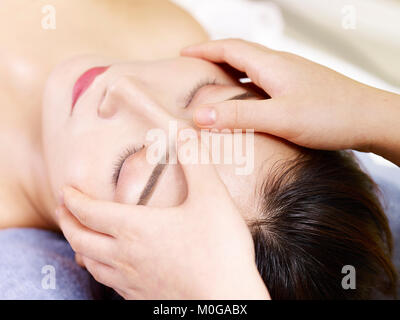 In der Nähe von schönen jungen asiatischen Frauen, die Gesicht Massage im Spa Salon, die Augen geschlossen. Stockfoto