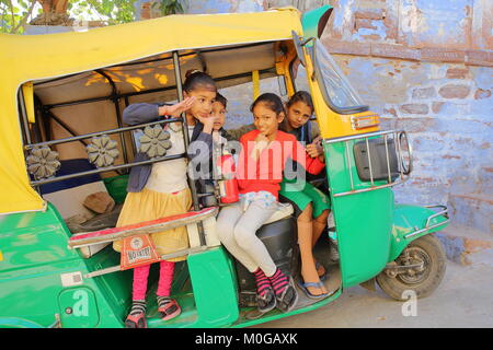 JODHPUR, Rajasthan, Indien - Dezember 17, 2017: Portrait der Kinder lächeln und posieren in einem Tuk Tuk Stockfoto