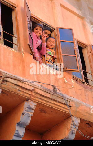 JODHPUR, Rajasthan, Indien - Dezember 17, 2017: Portrait von Kindern ein Lächeln auf den Lippen, und wenn man die Kamera von Ihrem Fenster Stockfoto