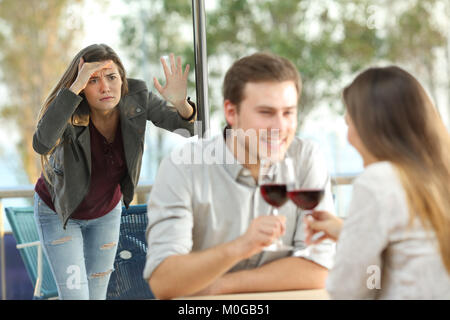 Stalker ex Freundin Spionage auf ein Paar in einem Coffee Shop Stockfoto