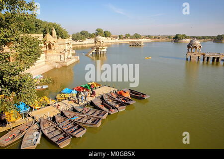 JAISALMER, Rajasthan, Indien - Dezember 19, 2017: Allgemeine Ansicht von Gadi Sagar See mit Paddeln Boote im Vordergrund und Chhatris Stockfoto