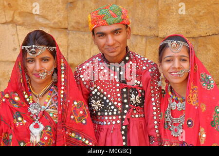 JAISALMER, Rajasthan, Indien - Dezember 21, 2017: Porträt eines jungen Mannes und zwei junge Frauen traditionell gekleidete mit bunten Kleidung und Juwelen Stockfoto