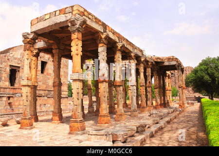 Antike Säulen mit Steinbildhauerei in Quwwat-Ul-Islam Moschee, Qutub Minar complex, New Delhi, Indien. Weltkulturerbe der UNESCO Stockfoto